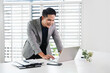 © Fahng - Happy professional business man company employee, young busy smiling male businessman entrepreneur or worker using laptop computer technology working at corporate office desk.