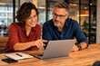 © hr-gold - Two professionals collaborating on a laptop in an office setting