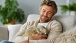 © Pinklife - A content man cuddles his green iguana on the couch, expressing the bond between humans and pets, showcasing a moment of tranquility and love in a cozy home environment.