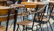 © Haha - Metal chain and padlock secure brown wooden chairs in an outdoor cafe setting, preventing their use