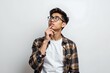© Chonly - A thoughtful young man with short dark hair and glasses, dressed in a casual plaid shirt over a plain white T shirt, standing against a plain white background