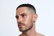 © JoeyMarut - Close up portrait of man with hydrated skin and soft light, showing short haircut, trimmed beard and contemplative expression on neutral background