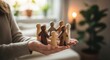 © Viktoryia - hands holding diverse wooden people figures in circle in cozy room concept for social community support group therapy family unity diversity inclusion and safe space teamwork