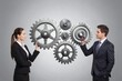 © Studicon - Business people holding metal gears to represent partnership and collaboration