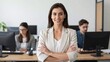 © Studicon - Confident businesswoman smiles in modern office while colleagues work at their computers