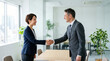 © Xenia - Diverse business people shaking hands across a table in a modern office. Smiling female candidate and male interviewer making a deal after a successful meeting