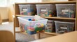 © Justlight - Focused medium shot of STEM toy bins neatly organized and labeled by age with the front bin highlighted and background bins gently out of focus.