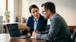 © Eve - Financial advisor consulting client with stock market charts on laptop. Business woman showing investment data and professional strategy to man in modern office interior.
