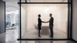 © Matj - Business handshake behind frosted glass in modern office corridor