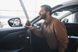 © Serhii - Man inspecting car interior at a dealership
