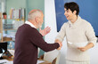 © JackF - Young man and elderly male colleague shake hands firmly and hold documents in hands in office