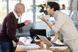 © JackF - Elderly and young men colleagues around table engaged in heated argument in tense office environment