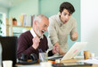 © JackF - Happy young and elderly men colleagues celebrating victory or positive result while looking at laptop screen in office