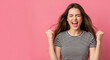 © Sarah - Excited young woman cheering with clenched fists perfect for celebrating business success and future goals