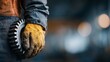 © JPminimal - Industrial worker handling metal gear in workshop focused environment close-up viewpoint for machinery concept