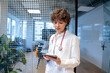 © Westend61 - Young doctor using tablet PC in front of spotted glass at office