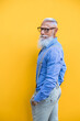 © oneinchpunch - Senior hipster man portrait on yellow background