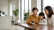 © Николай Срибяник - Senior woman, mother and daughter looking at smartphone together at table.