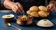 © Berkah - Chef garnishing delicious Indian Chana Masala, served with Puri, rice, raita.