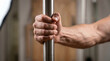 © Peeradontax - Close-up of hand gripping a vertical metal pole