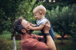 © Halfpoint - Father and toddler feeding chickens in backyard garden.