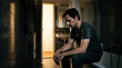 © Len_mik - Man sitting in a dark bathroom feeling introspective and contemplative against a dimly lit backdrop
