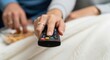 © Nataly - Cozy evening with couple watching TV and enjoying snacks while using remote control. Comfortable setting includes snacks in bowl, warm blanket, and focused expressions.