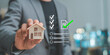 © Siam - Real estate agent holding wooden house model while selecting digital document checklist for home inspection property approval and mortgage loan verification process.