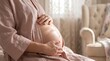 © Ruslan Abdullin - Pregnant woman holding belly in cozy home interior close up