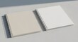 © MindRender - Two spiral bound notebooks with blank white and beige pages on a gray surface for writing or drawing