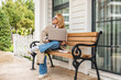 © ADDICTIVE STOCK - Woman enjoying outdoor work on a wooden bench