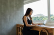 © crizzystudio - Asian woman working on laptop at modern workspace