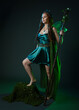 © faestock - Full length portrait of female model wearing fantasy fairy costume, green dress, cloak, butterfly wings and crown. Full length walking pose holding druid staff.  isolated on dark studio background.
