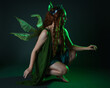 © faestock - portrait of female model wearing fantasy fairy costume, green dress, cloak, butterfly wings and crown. full length sitting pose, kneeling on floor, dark studio background.