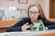 © Михаил Решетников - Caucasian young woman making a model of a building. Student of the construction university.