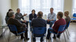 © Hasan Asib - Diverse group adults engage in open discussion during support group meeting in bright room, sharing experiences and offering mutual encouragement, fostering sense community and understanding.
