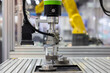 © Kalyakan - Industrial robotic arm with machine vision camera picking metal gears in automated factory line, Robotic gripper handling steel machine, Automated robotic system smart factory.