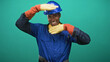 © Krakenimages.com - Man construction worker in blue hardhat and yellow headphones raises gloved hands and shows wrench in studio; pride.