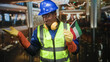 © Krakenimages.com - Man construction worker in hardhat holds kuwait flag and gestures palm up in hotel lobby; pride solidarity.