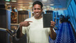 © Krakenimages.com - Man pointing finger at black book while smiling and holding it in airport terminal; confidence opportunity.