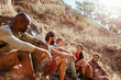 © Marko Geber - Group of friends resting during hike on sunny hillside