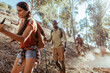 © Marko Geber - Friends hiking on a sunny forest hillside trail