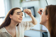 © Davor - Woman applying mascara in home bathroom mirror