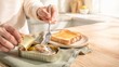 © dvoevnore - Canned sardines being served on toast with a fork in a cozy kitchen setting