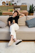 © LIGHTFIELD STUDIOS - Young beautiful woman enjoys a relaxing moment at home while using her phone and smiling