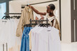 © Iryna - Stylish African American Woman Choosing Clothes in Modern Fashion Boutique
