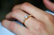 © homeganko - Elegant Gold Ring With Center Stone and Side Gems on Hand in Soft Lighting