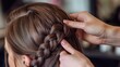© Fotograf - A person styling their own hair in a braid, often used for personal use or editorial purposes