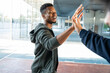 © ADDICTIVE STOCK - Man giving high five after outdoor sport practice session