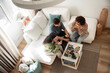 © ADDICTIVE STOCK - Friends share snacks in bright living room at home